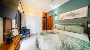 Une chambre à coucher moderne avec un lit, une chaise, une armoire et un tableau accroché au mur.