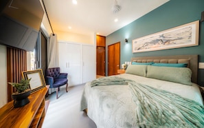 Una camera da letto moderna con un letto, una sedia, un armadio e un quadro appeso al muro.