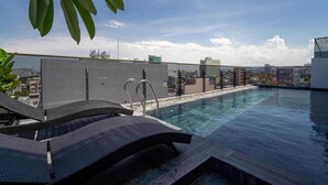 A rooftop swimming pool with lounge chairs and a cityscape view. - HSuites Riverside Hotel & Apartment  (An Hai)
