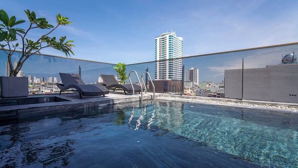A rooftop pool with lounge chairs and a cityscape view. - HSuites Riverside Hotel & Apartment  (An Hai)