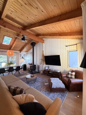 A cozy living room with a large sofa, a coffee table, and a flat-screen TV.