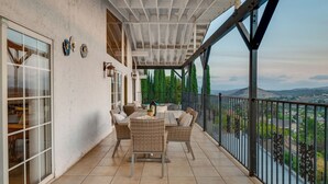 An outdoor patio with a table and chairs, a railing, and a view of the landscape. - Sol vista villa a Spacious 4-bedroom house, a poolside living above the city. (El Cajon)