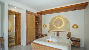 Un dormitorio con una cama grande, cabecero de madera y un revestimiento de pared de piedra.