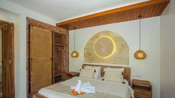 Un dormitorio con una cama grande, un armario de madera y una pared de piedra con una lámpara circular.