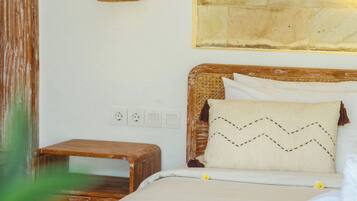 A bed with a headboard, a bedside table, a wall-mounted light fixture, and a wall with a circular design.