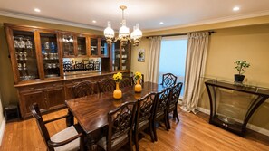 A dining area with a wooden table, chairs, a glass cabinet, and a chandelier. - Thornhill Luxury Retreat | Perfect for Families, Groups & Business Travellers (Markham)