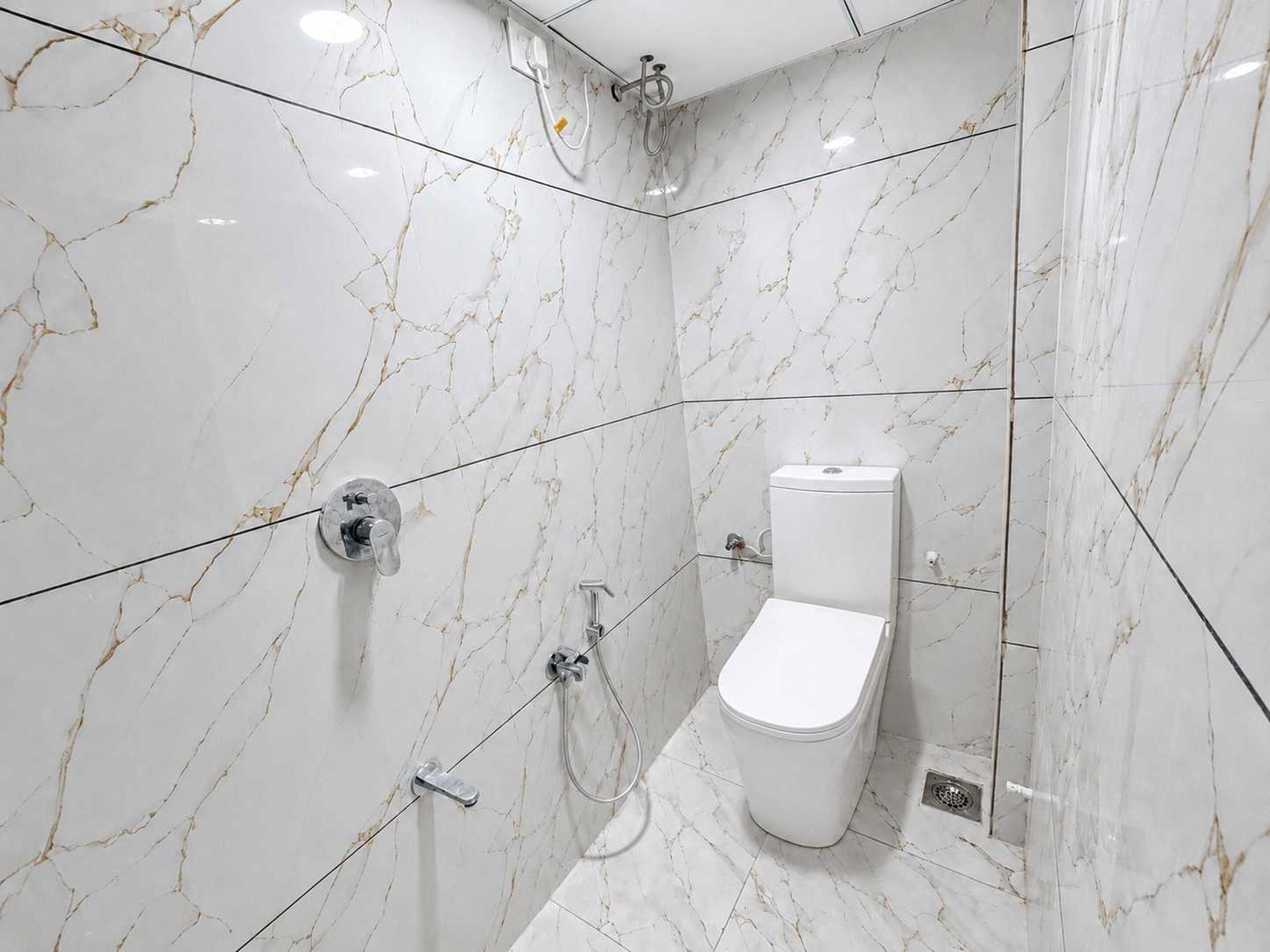 Un baño moderno con inodoro, ducha y panel de control.