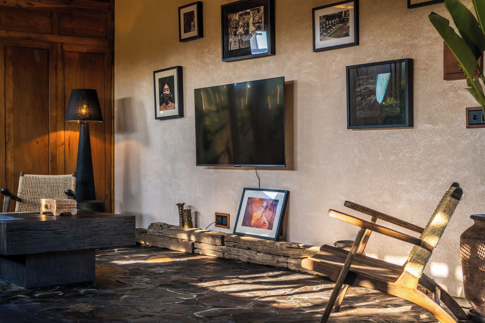Een gezellige zithoek met een stenen openhaard, een aan de muur bevestigde televisie en een rustieke houten stoel.