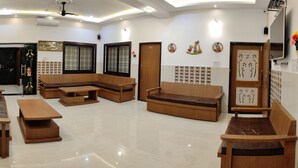 A modern living room with a sofa, a coffee table, and a dining table. - Shubh Ashray (UDAIPUR)