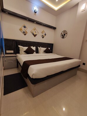 Ein modernes Schlafzimmer mit einem großen Bett, einem Nachttisch und einer Wandleuchte.