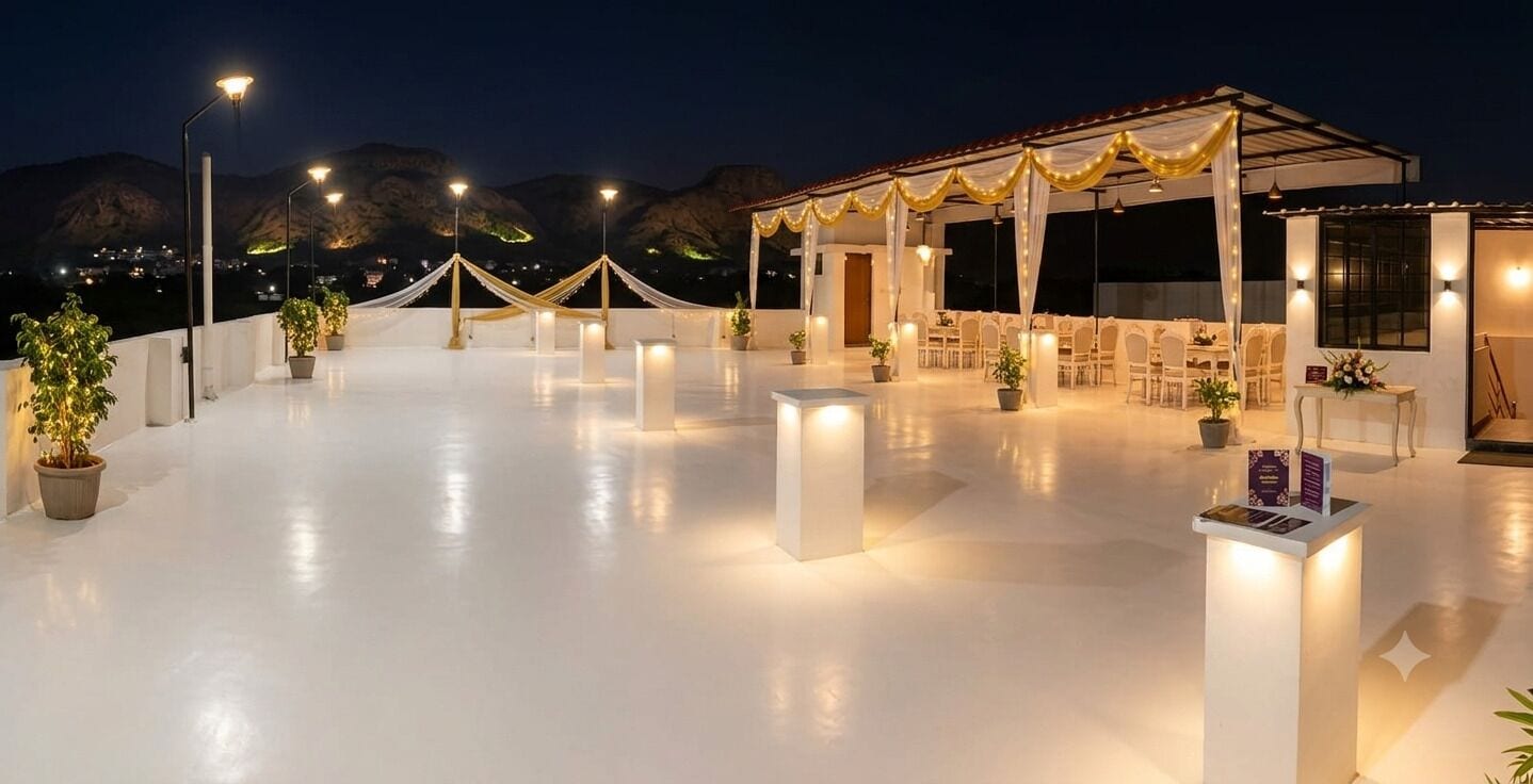 An outdoor terrace with a covered seating area, potted plants, and a clear view of the mountains in the background.