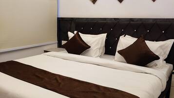 Un lit bien fait, avec une couverture marron, une tête de lit sombre et trois éléments décoratifs fixés au mur.