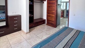 A bedroom with a bed, wardrobe, built-in shelves, a ceiling fan, and a window. - Perfect retreat 2 blks from beach in Villa Obregón neighbourhood  Melaque! (San Patricio)