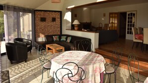Ein Wohnzimmer mit einer Couch, Sesseln, einem Couchtisch und einem Kamin.