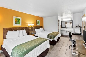 Een hotelkamer met twee bedden, een bureau, een stoel, een spiegel en kunstwerken aan de muren.