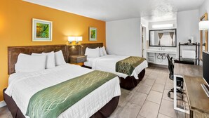 Ein Hotelzimmer mit zwei Betten, einem Schreibtisch, einem Stuhl, einem Spiegel und Bildern an den Wänden.