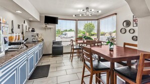 Eine moderne Küche mit Essbereich, einem Flachbildfernseher und Blick ins Freie.