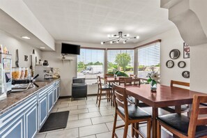 Een moderne keuken met een eethoek, een flatscreen televisie en uitzicht op buiten.