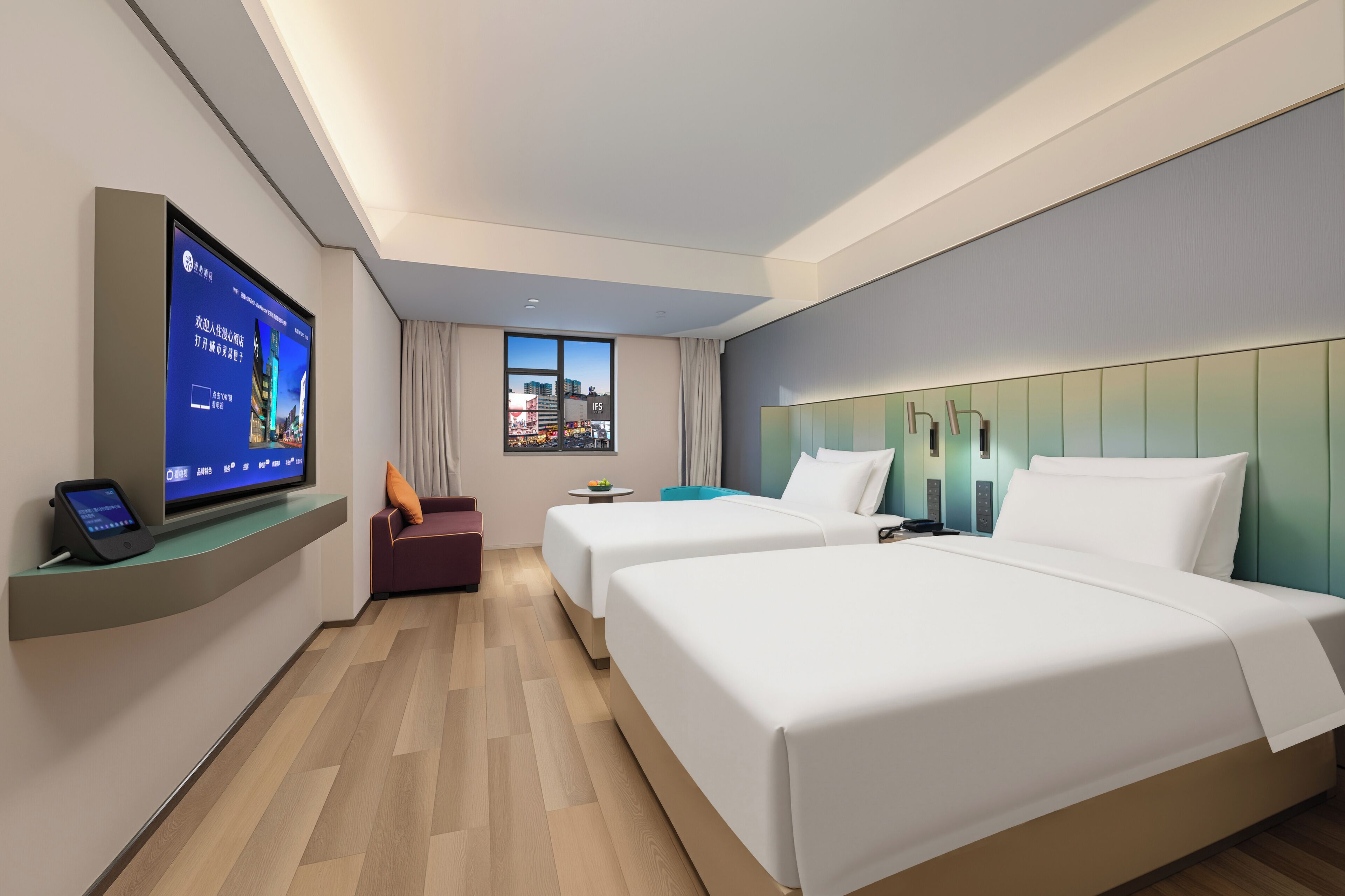 Une chambre d’hôtel avec deux lits, une télévision, un bureau et une fenêtre donnant sur la ville.