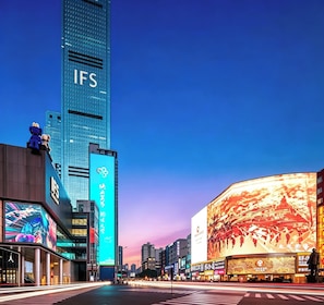 Paisagem urbana com edifícios modernos, incluindo um arranha-céu em destaque com a inscrição 'IFS'.