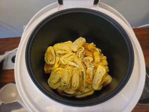 Una fritadora d'aire amb pastissos a trossos.