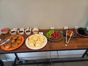 Una mesa de buffet con diversos alimentos y utensilios.