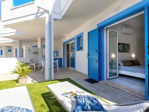 A modern outdoor living area with a pool, lounge chairs, and a dining set. - Perla Blu by Interhome (Valledoria)