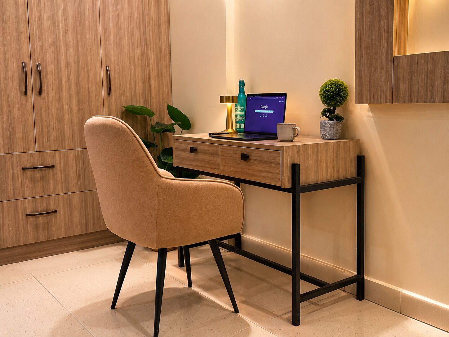Um espaço de escritório moderno com escrivaninha, cadeira, laptop e objetos decorativos.