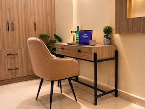 A modern office space with a desk, chair, laptop, and decorative items. - C Suites Maclean (Bengaluru)