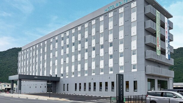 A multi-story hotel with a modern design, featuring a prominent entrance and a balcony on the upper floor. - Hotel Route Inn Tamba-Hikami Inter- (Tamba)