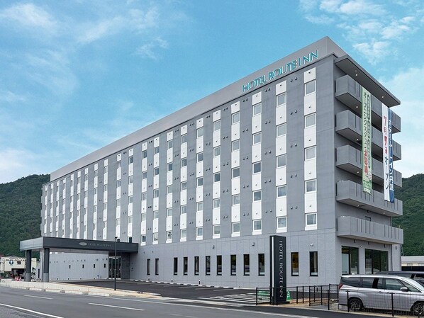 A multi-story hotel with a modern facade, multiple balconies, and a prominent signage indicating its name. - Hotel Route Inn Tamba-Hikami Inter- (Tamba)