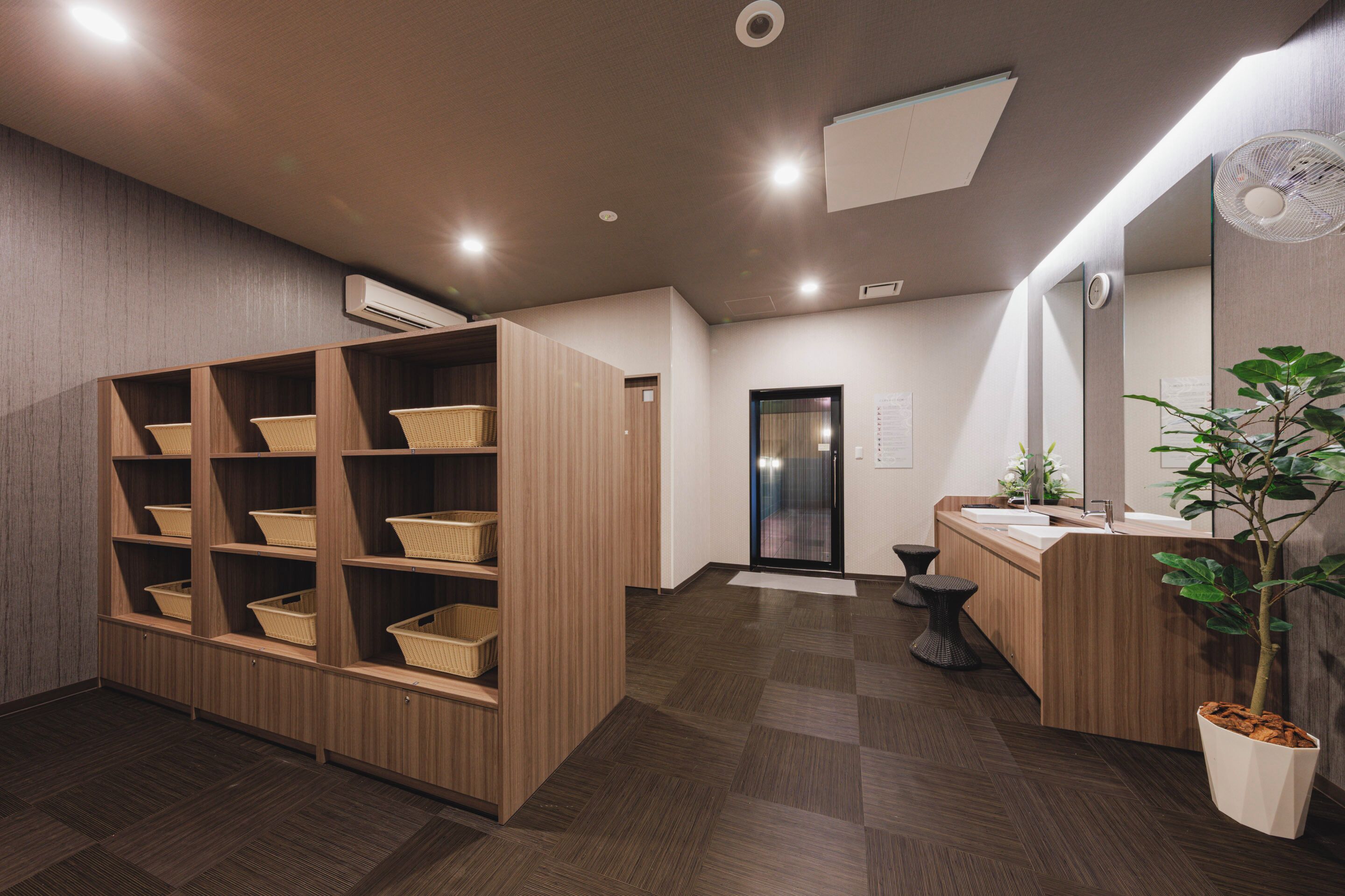 A modern bathroom with wooden shelving, a sink, and a mirror.
