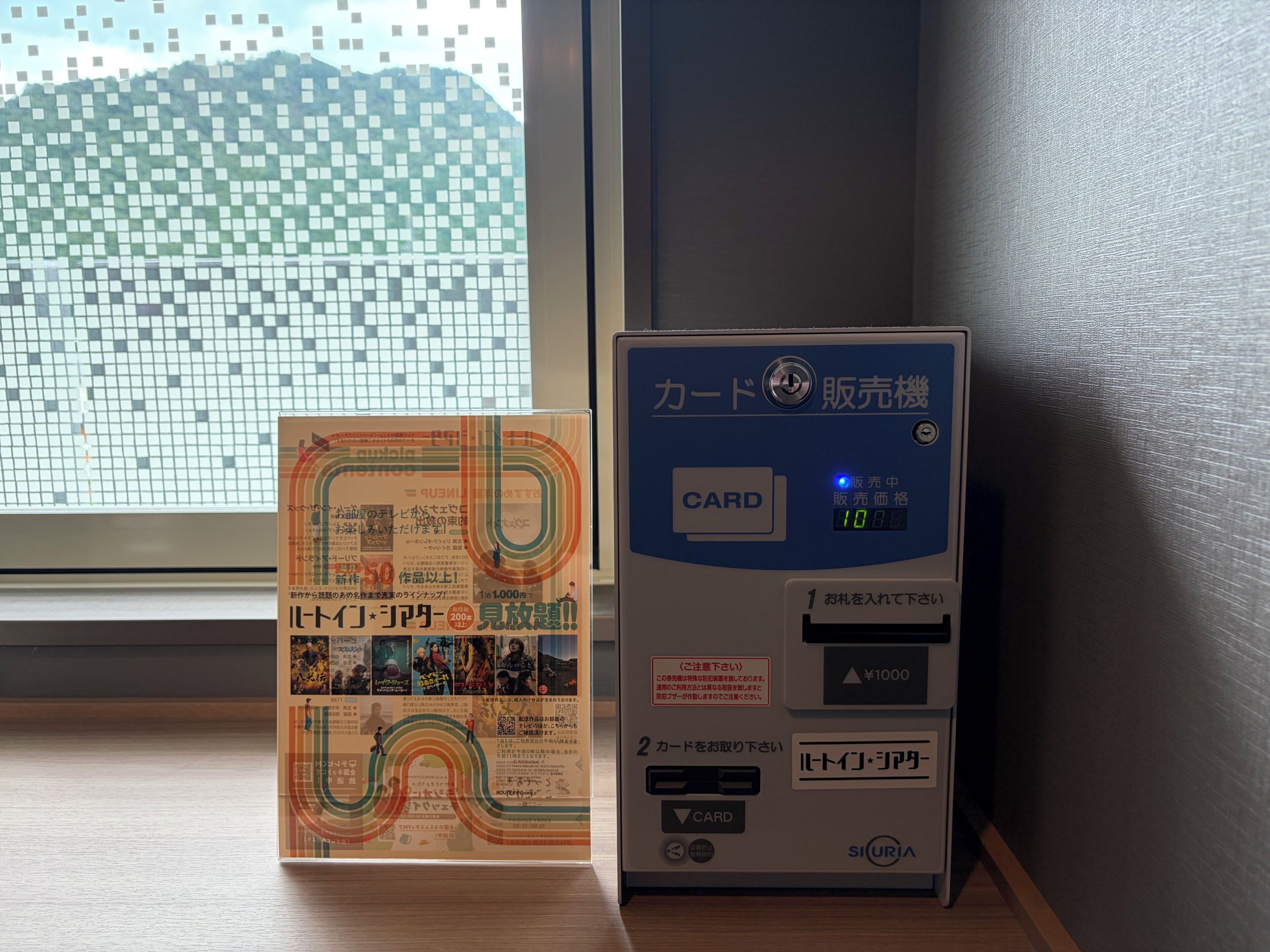 A card payment machine and a promotional poster on a wooden surface.