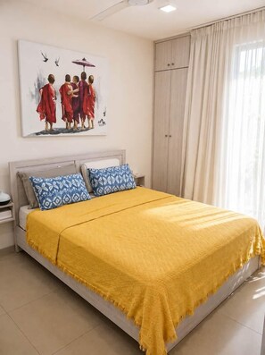 Ein Schlafzimmer mit Bett, Nachttisch, Kleiderschrank und einem Gemälde an der Wand.