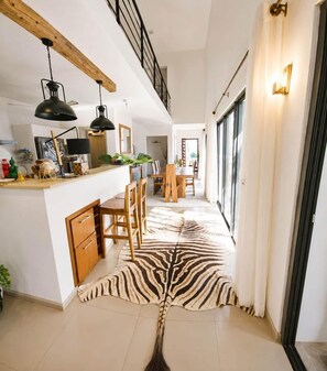 A modern kitchen with a wooden countertop, two pendant lights, and a zebra-print rug. - Mont Choisy 3-Bedroom Villa, Grand Baie (Grand Baie)