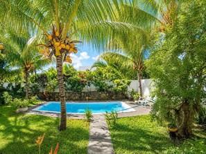 A swimming pool surrounded by lush greenery and palm trees. - Mont Choisy 3-Bedroom Villa, Grand Baie (Grand Baie)