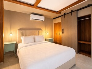 A bedroom with a large bed, bedside tables, an air conditioning unit, a wardrobe, and a sliding door. - Central Bella Vista Apt w/ Terrace & Fast WiFi (Panama City)