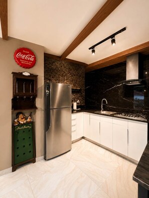 A modern kitchen with a stainless steel refrigerator, a stone backsplash, and a wooden ceiling. - Central Bella Vista Apt w/ Terrace & Fast WiFi (Panama City)
