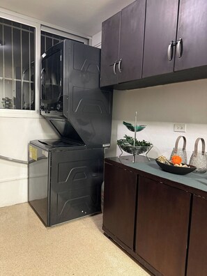 A compact kitchen with a built-in microwave, a small sink, and dark wooden cabinets. - Exclusive Paitilla Apt w/ Free Parking, Steps to (Panamá)