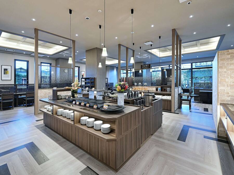 A modern hotel lobby with a central reception desk, seating area, and large windows offering views.