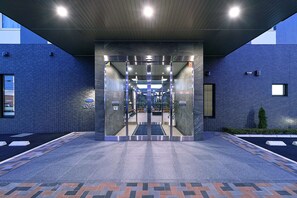 A hotel entrance with a modern design, featuring a glass door, a tiled floor, and a clear view into the interior. - Hotel Route Inn Matsuyama north (Matsuyama)