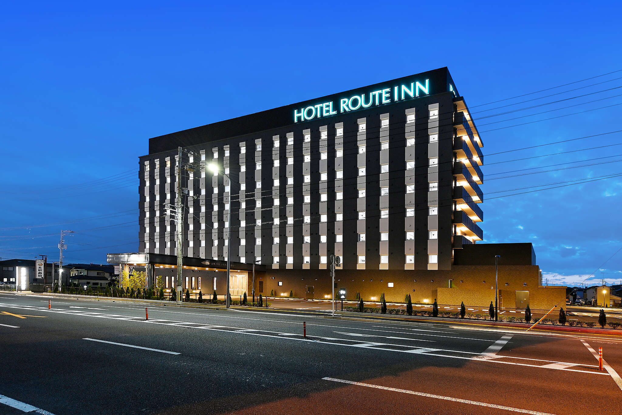 A modern hotel building with a prominent sign reading 'HOTEL ROUTE INN.'
