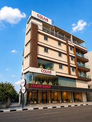 A multi-story hotel named COLIVE with a modern design, featuring balconies and large windows. - C Suites Shelton (Bengaluru)