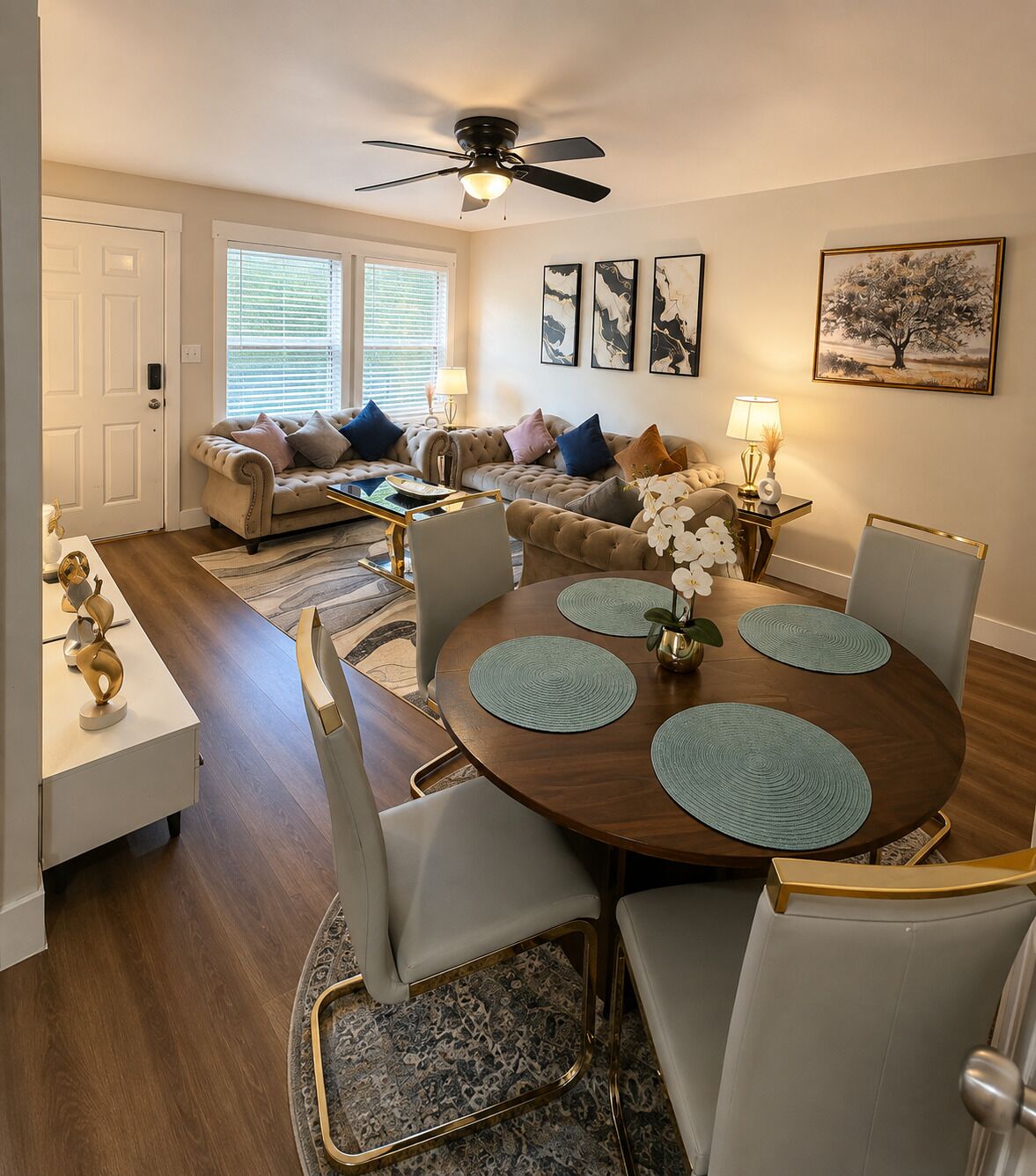A dining area with a round table, chairs, and a ceiling fan.