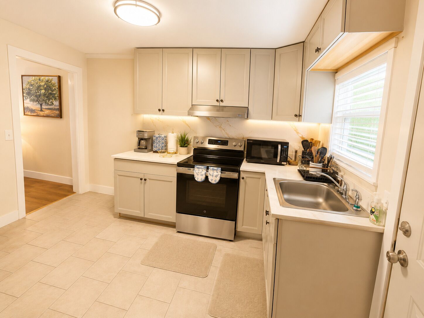 A modern kitchen with a built-in oven, microwave, and stainless steel sink.