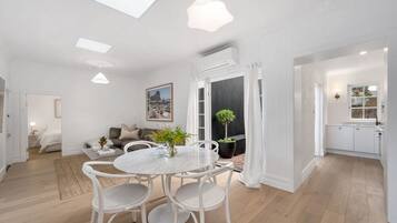 A modern living room with a dining area, a kitchen, and a bedroom.