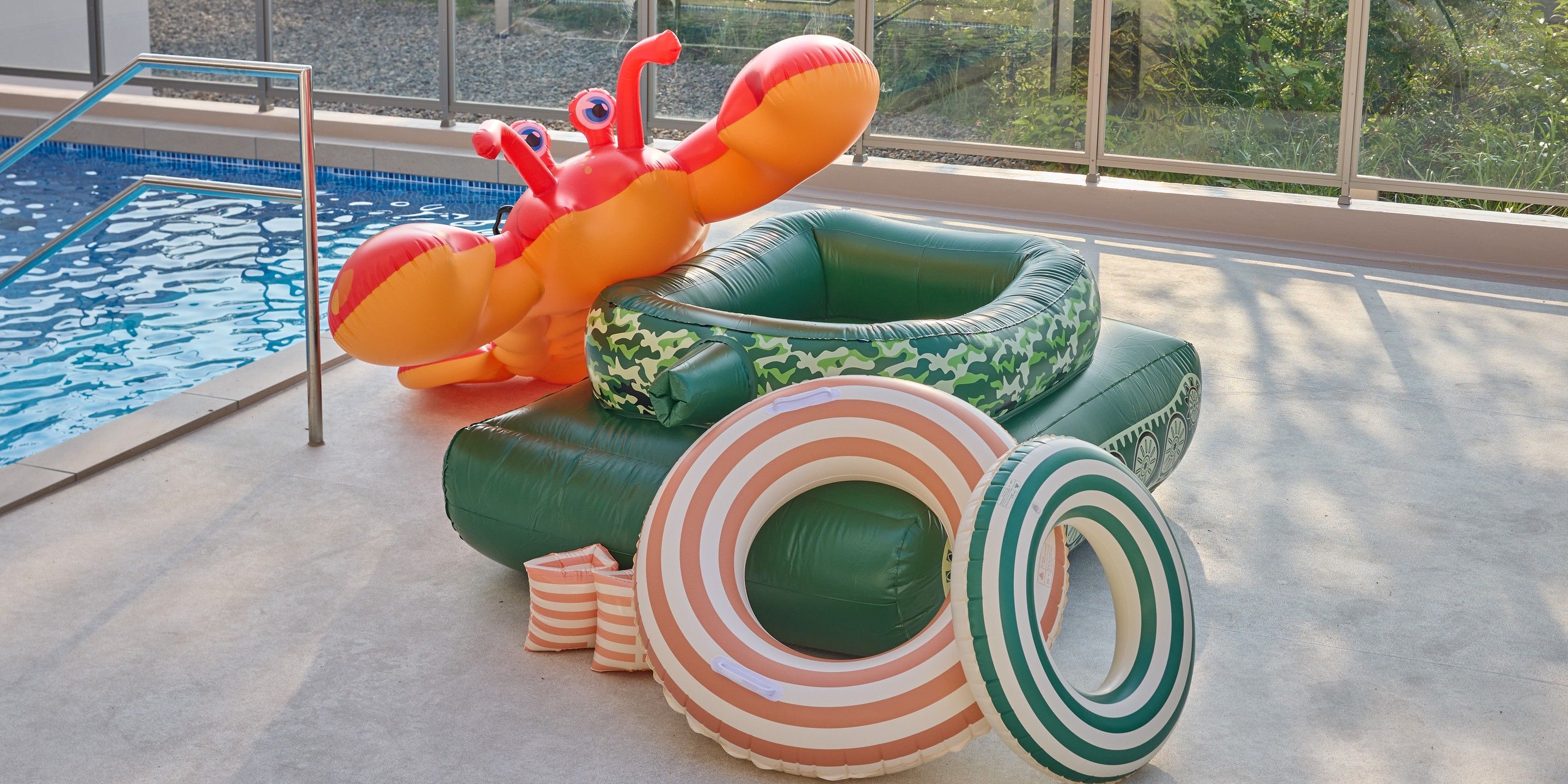 A pool area with inflatable pool toys and a view of the outdoors.