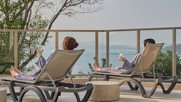 Dos sillones de descanso con vista al mar y las colinas.