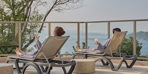 Deux fauteuils confortables avec vue sur la mer et les collines.