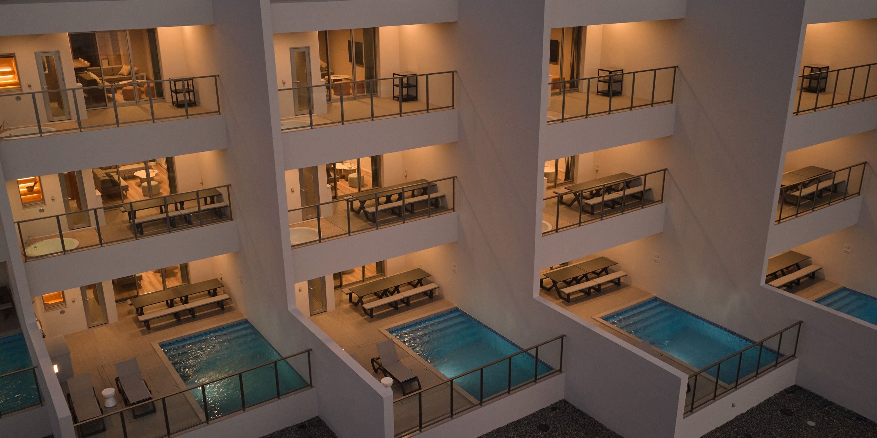 A multi-level hotel with balconies, a swimming pool, and a dining area.